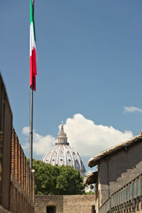 Low angle view of flags on building against sky