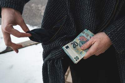 Midsection of woman holding paper currency