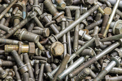 Full frame background of used automobile bolts heap, old and dirty