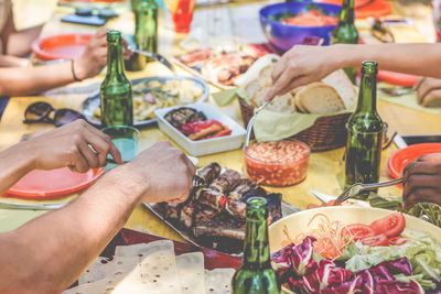 Cropped hands having various food at table