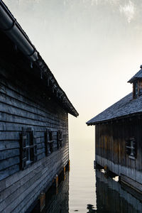 View of house by lake against sky