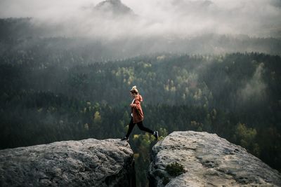 Man standing on rock against mountains