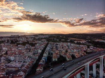 High angle view of street amidst buildings against sky during sunset