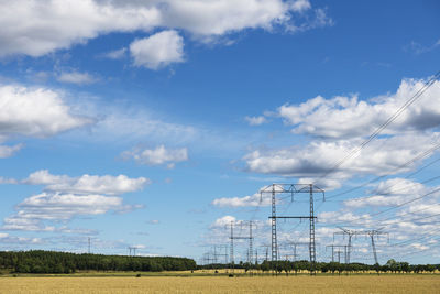 Electricity pylons against blue sky