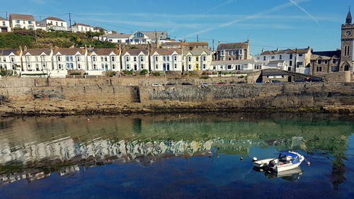 Sailboats moored on river by buildings in town