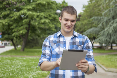 Happy boy using mobile phone in park