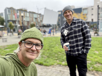 Portrait of smiling young man standing in city