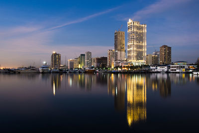 Illuminated buildings in city against sky