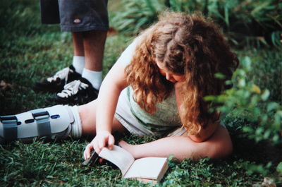 Rear view of woman sitting on grass