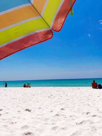 Scenic view of pensacola beach from under a parasol, against a vibrant sky