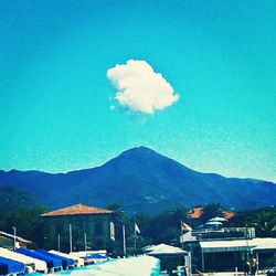 Scenic view of sea and mountains against blue sky