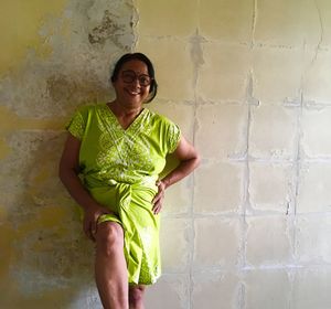 Portrait of smiling young woman standing against wall