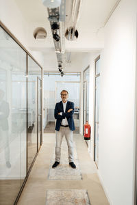 Full length portrait of man standing in corridor