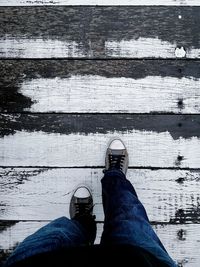 Low section of person with umbrella on wood