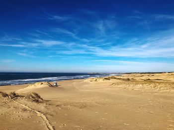 Scenic view of beach against blue sky
