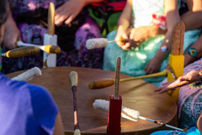 Midsection of people playing drums