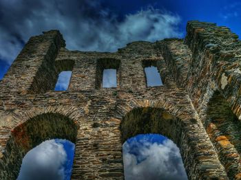 Low angle view of old building against cloudy sky