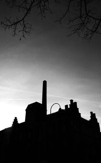 Low angle view of silhouette built structure against sky at sunset