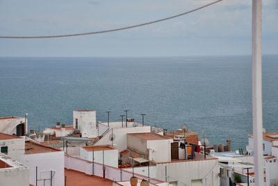 High angle view of townscape by sea against sky