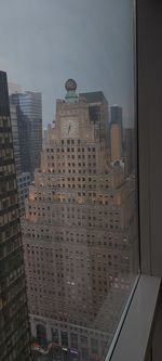High angle view of buildings against sky seen through glass window