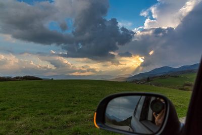 Scenic view of grassy field against cloudy sky