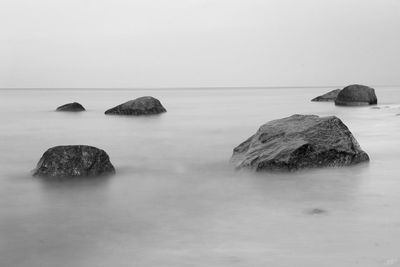 Rocks in sea against sky