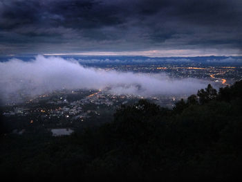 Aerial view of cityscape against cloudy sky