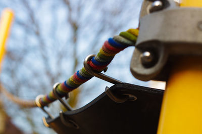 Low angle view of rope tied on metal