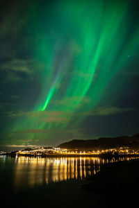 Scenic view of lake against aurora borealis at night