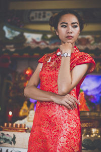 Young woman standing with hand on chin