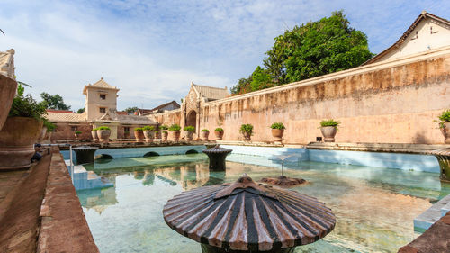 View of swimming pool by building against sky