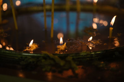 Close-up of lit candles in temple