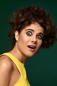 Portrait of young woman against black background