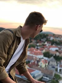 Side view of young man looking at sunset