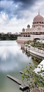 View of building by lake against sky
