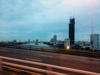 View of buildings in city against cloudy sky