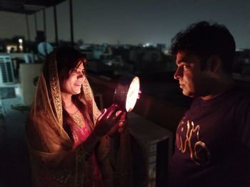 Smiling woman celebrating karva chauth at night