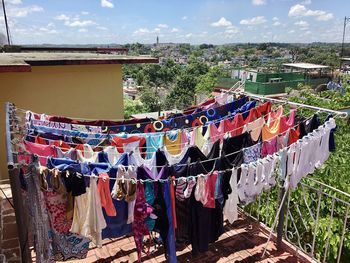 Clothes drying on clothesline against sky in city