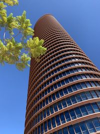 Low angle view of modern building against clear blue sky