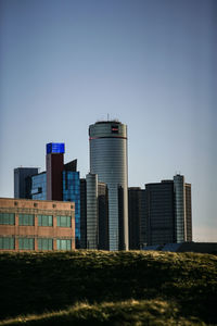 Modern buildings in city against clear blue sky