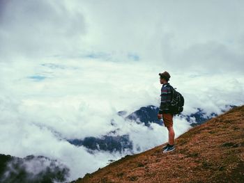 View of man standing on mountain against sky