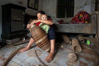 Full length of mother and girl sitting on floor