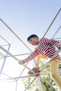 A young boy climbs up in a public playground