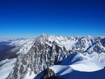 Scenic view of snowcapped mountains against clear blue sky