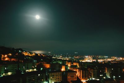 Illuminated cityscape against sky at night