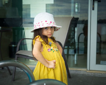 Beautiful little gorgeus lovely toddler girl in mustard summer look clothes, fashion dress, and hat.