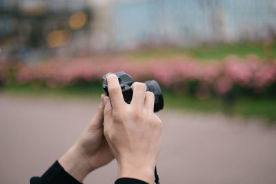 Close-up of female hands photographing garden using digital camera