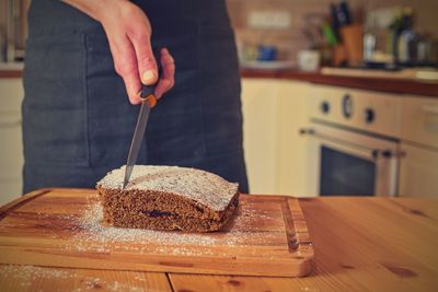 Man cutting classic gingerbread in traditional kitchen. a classic gingerbread recipe family home.