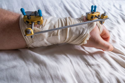 Close-up of person working on bed