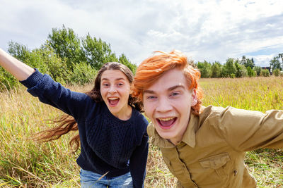 Portrait of smiling friends standing on field